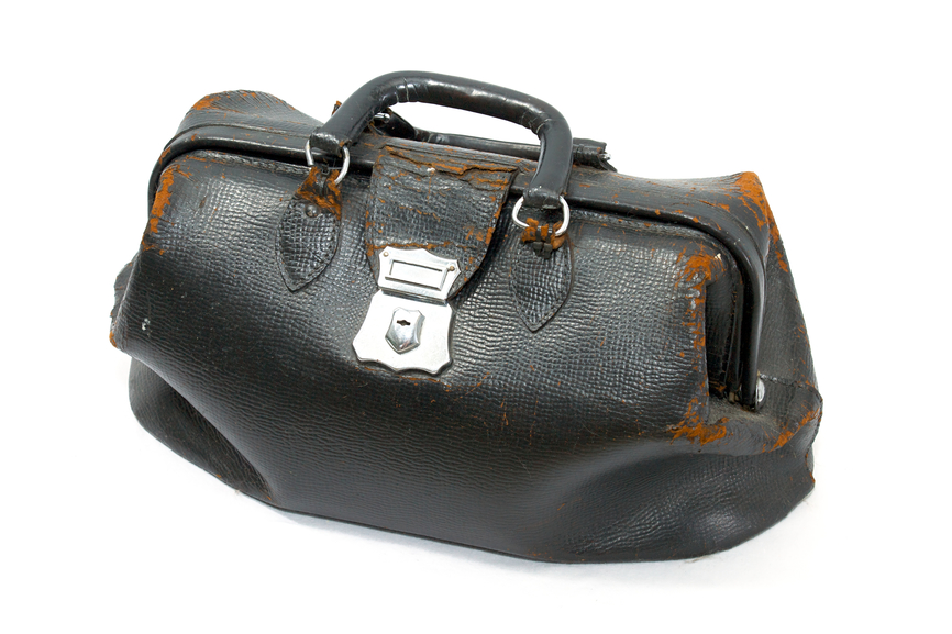 an old black leather doctor's bag, isolated on white, leather is dry and cracked