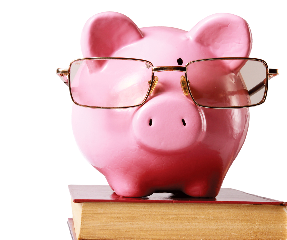 piggy bank with glasses and book  isolated white background
