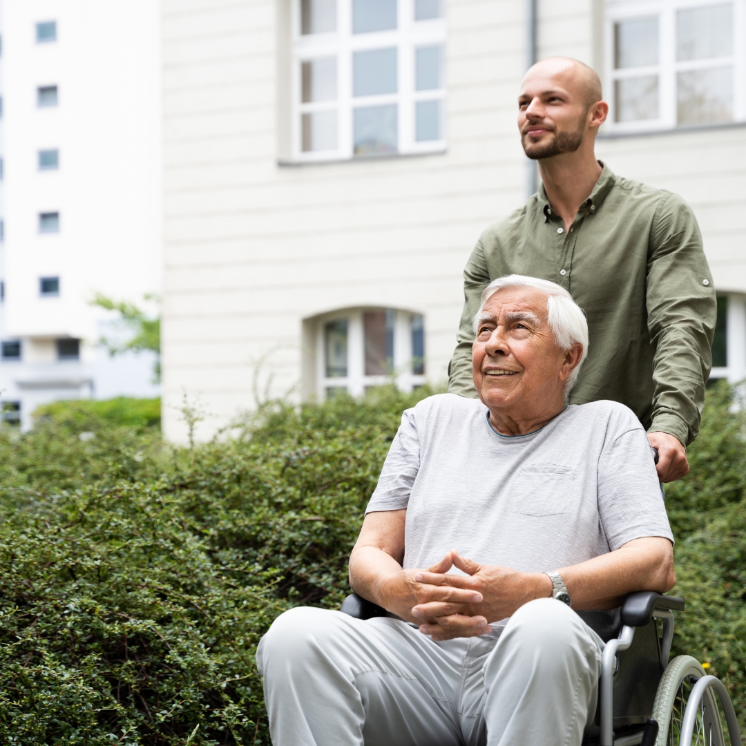 man wheeling a senior man in a wheelchair